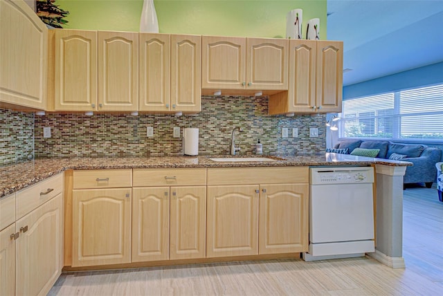 kitchen featuring light brown cabinetry, light stone countertops, sink, and dishwasher