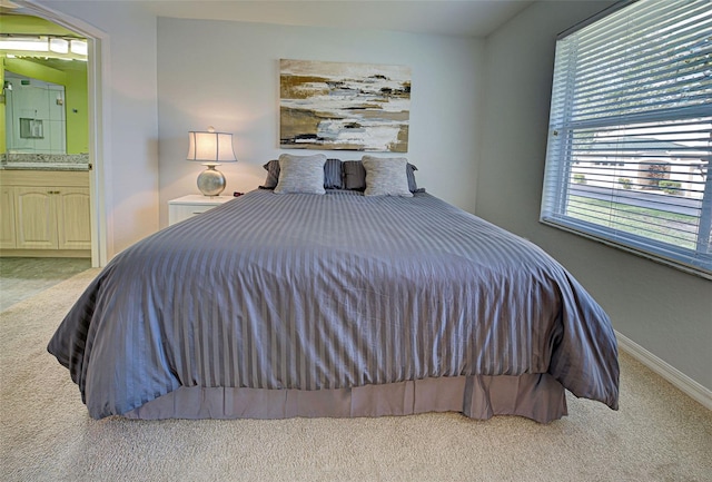 bedroom with light colored carpet and connected bathroom