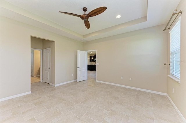 unfurnished bedroom with a raised ceiling and ceiling fan