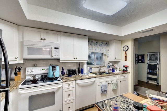 kitchen featuring light stone counters, tasteful backsplash, white cabinets, white appliances, and sink