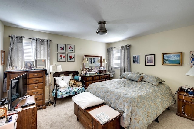 carpeted bedroom featuring multiple windows and ceiling fan