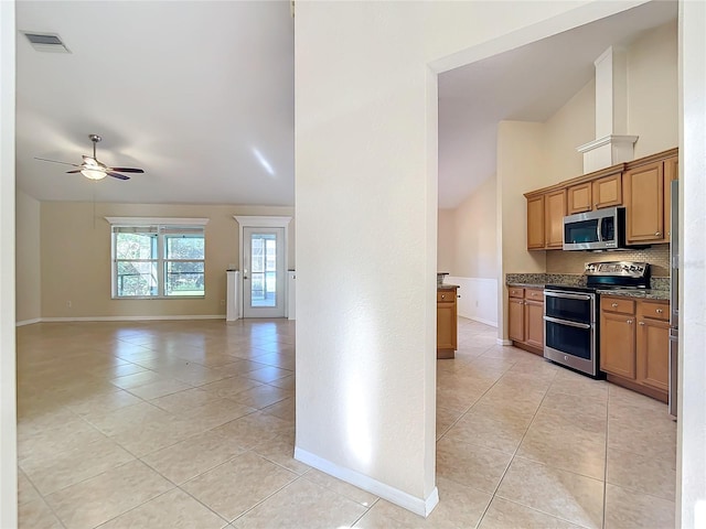 kitchen with high vaulted ceiling, stainless steel appliances, backsplash, light tile patterned floors, and ceiling fan