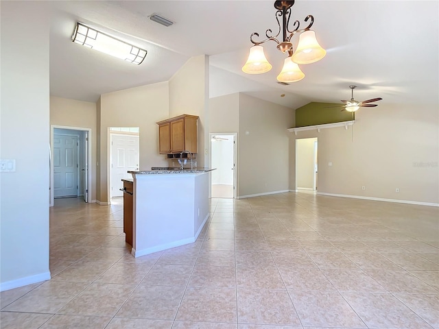 kitchen with ceiling fan with notable chandelier, lofted ceiling, light tile patterned floors, and pendant lighting