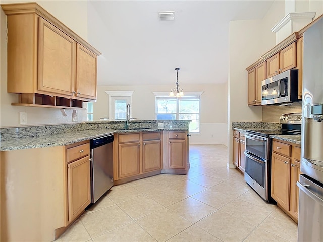 kitchen featuring sink, kitchen peninsula, hanging light fixtures, stainless steel appliances, and light tile patterned floors