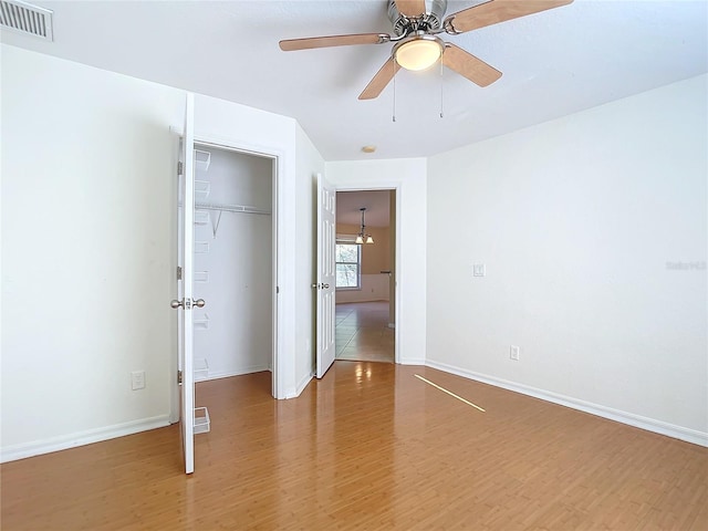 unfurnished bedroom with a closet, wood-type flooring, and ceiling fan