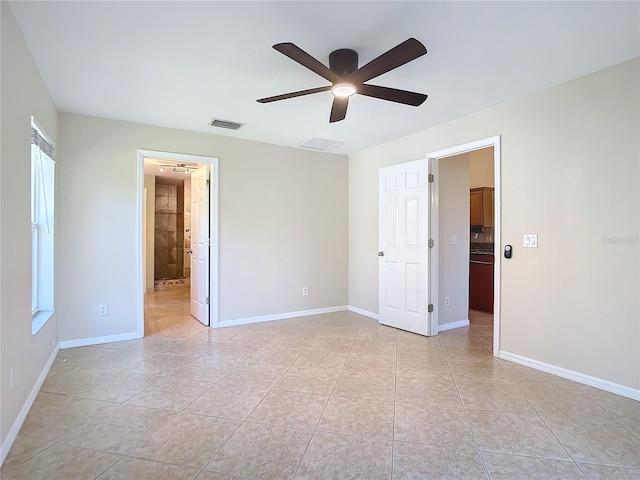 unfurnished bedroom featuring light tile patterned floors, ensuite bath, and ceiling fan