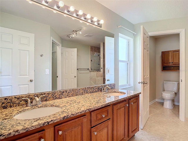 bathroom featuring vanity, tile patterned flooring, a shower with shower door, and toilet