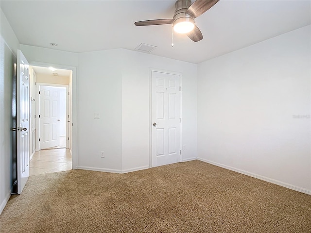 unfurnished bedroom featuring ceiling fan, light colored carpet, and a closet