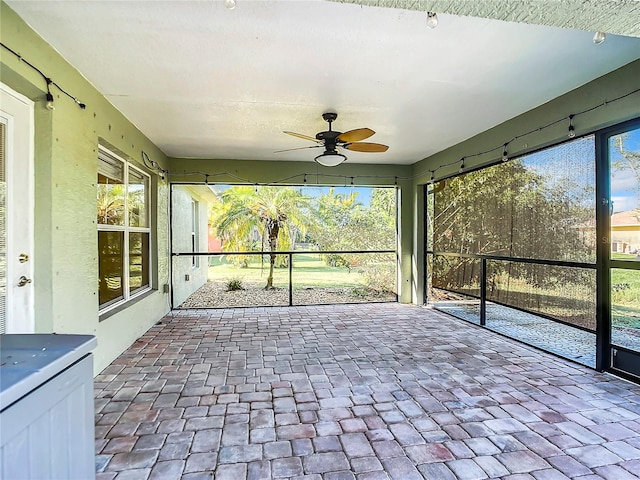 unfurnished sunroom with ceiling fan