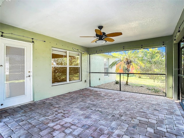 unfurnished sunroom featuring ceiling fan