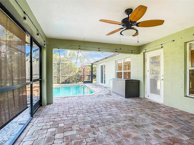 unfurnished sunroom featuring ceiling fan and a pool