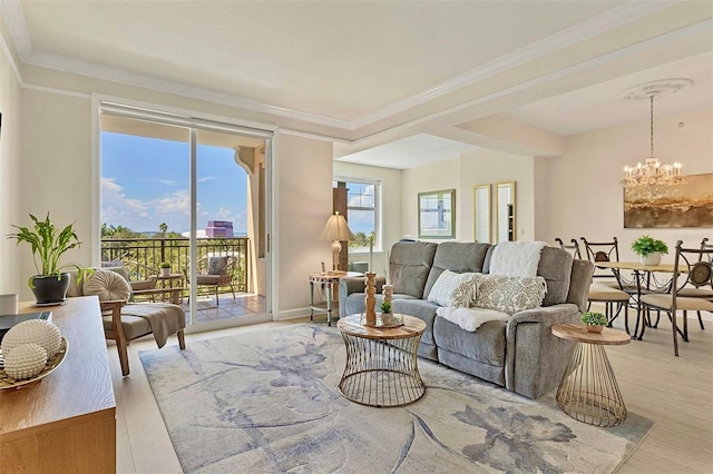 living room featuring an inviting chandelier, light hardwood / wood-style flooring, and crown molding