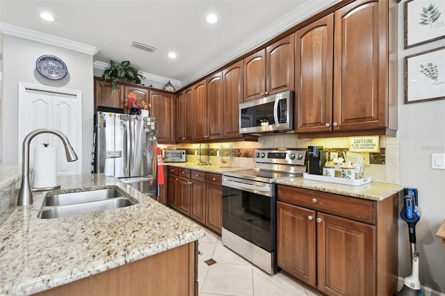 kitchen featuring appliances with stainless steel finishes, decorative backsplash, light stone countertops, crown molding, and sink