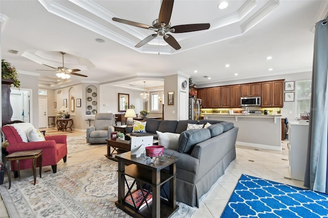 tiled living room featuring a tray ceiling, ceiling fan, and crown molding