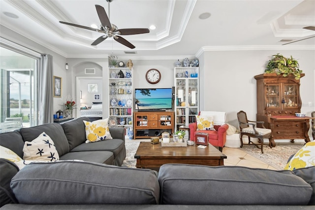 living room with crown molding, ceiling fan, and a raised ceiling