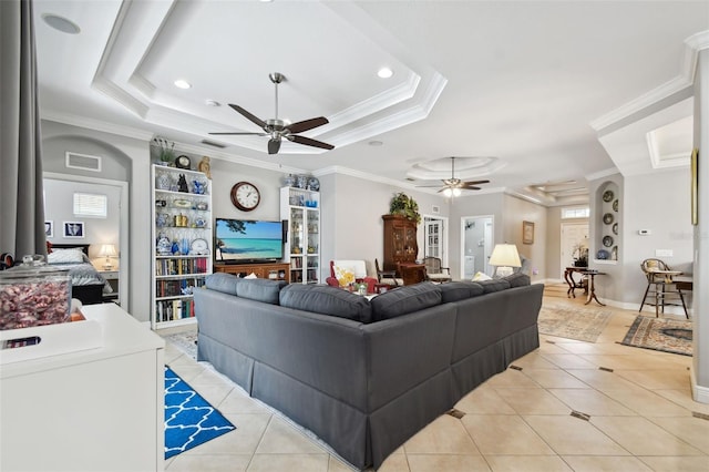 tiled living room with a tray ceiling, ornamental molding, and ceiling fan