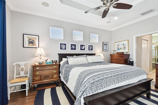 bedroom featuring crown molding, connected bathroom, dark wood-type flooring, and ceiling fan