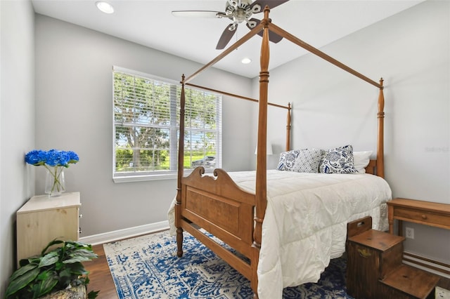 bedroom featuring multiple windows, hardwood / wood-style floors, and ceiling fan