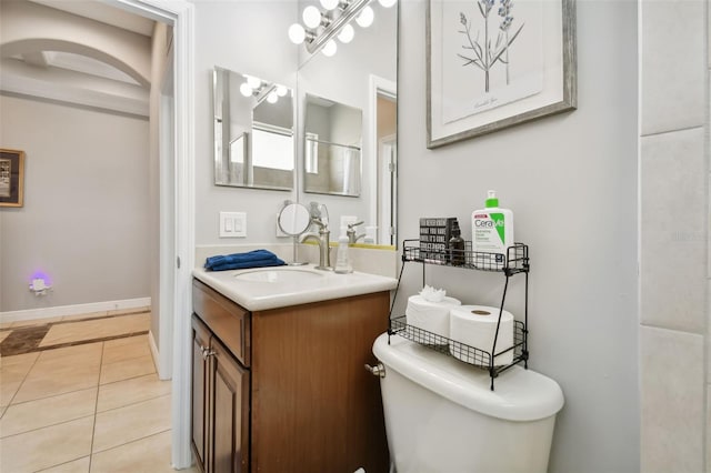 bathroom with tile patterned flooring, a chandelier, vanity, and toilet