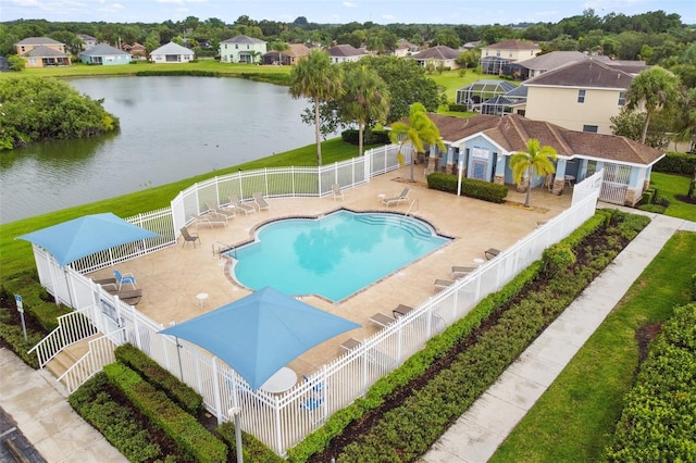 view of swimming pool featuring a lawn, a water view, and a patio area