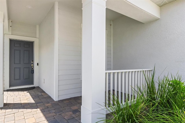 view of exterior entry featuring covered porch