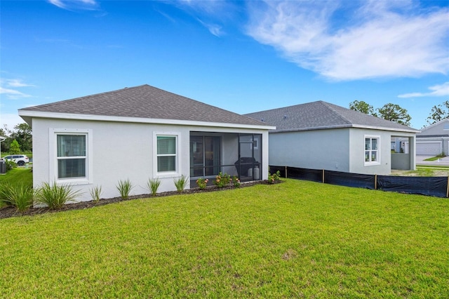 rear view of house with a sunroom and a yard