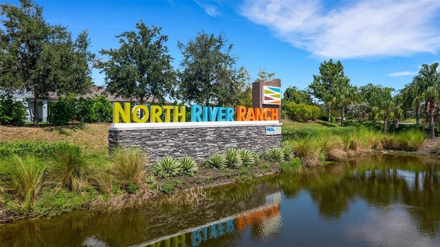 community / neighborhood sign featuring a water view