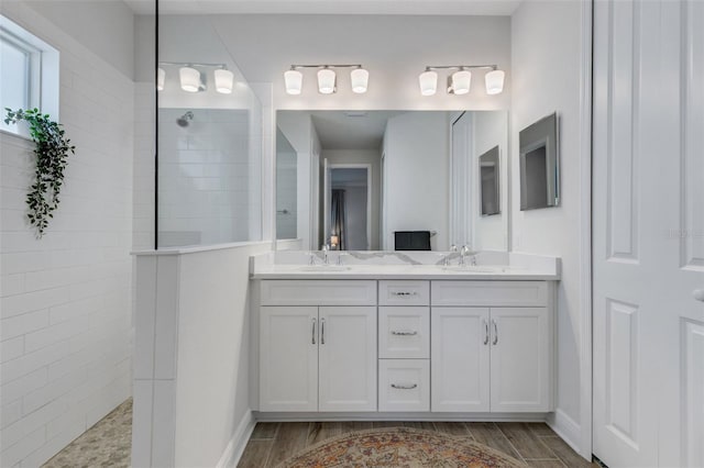 bathroom featuring a tile shower, vanity, and hardwood / wood-style floors