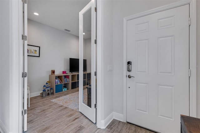 foyer entrance featuring french doors and light hardwood / wood-style flooring