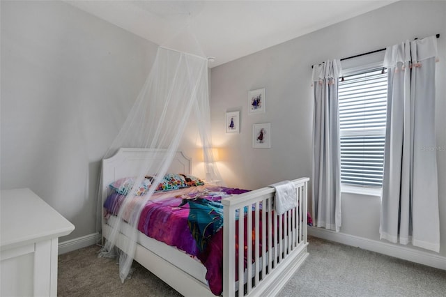 bedroom with light colored carpet and baseboards