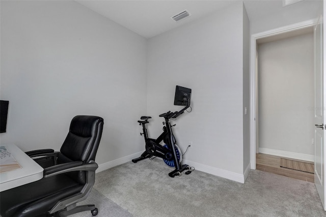 carpeted office space featuring visible vents and baseboards