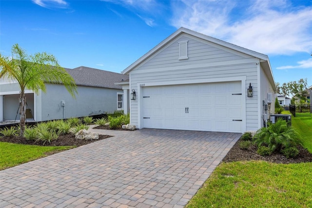 ranch-style house with decorative driveway and fence