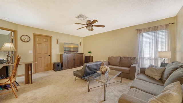 carpeted living room with a textured ceiling and ceiling fan