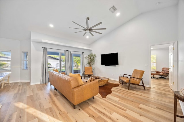 living room featuring high vaulted ceiling, a wealth of natural light, light hardwood / wood-style floors, and ceiling fan