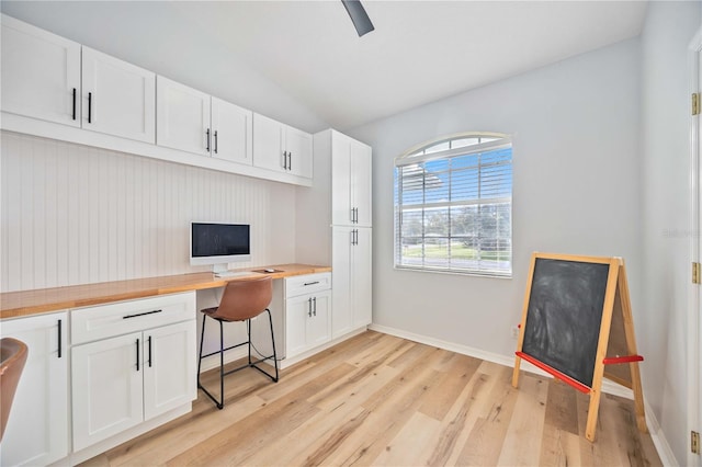 office featuring light hardwood / wood-style flooring, lofted ceiling, and built in desk