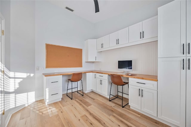 office with light hardwood / wood-style flooring and built in desk