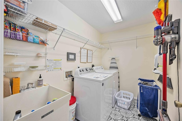 clothes washing area featuring washer and clothes dryer and sink