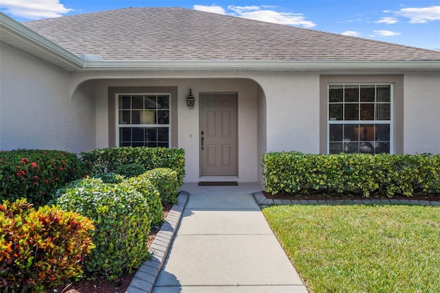 doorway to property featuring a lawn