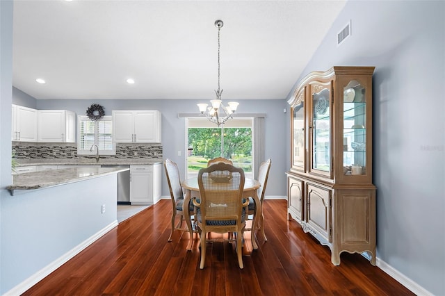 dining area featuring a healthy amount of sunlight, dark hardwood / wood-style flooring, a chandelier, and sink