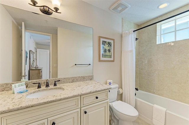 full bathroom with shower / tub combo with curtain, vanity, a textured ceiling, and toilet