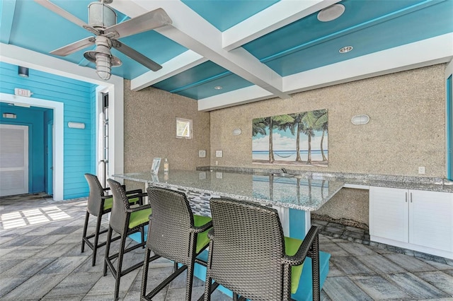 view of patio / terrace with ceiling fan and an outdoor bar