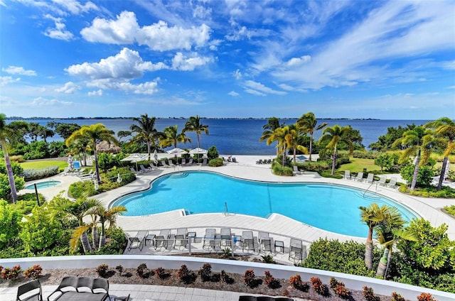 view of swimming pool featuring a patio area and a water view