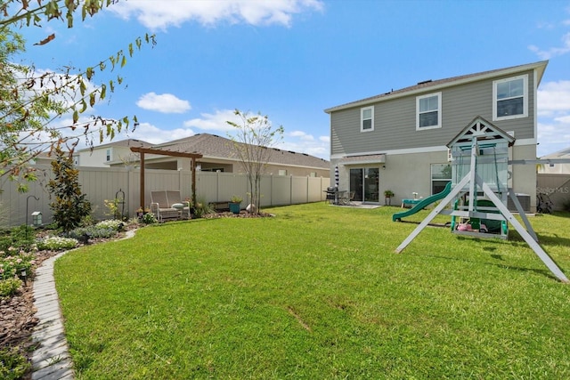 rear view of house with a yard and a playground