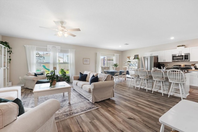 living room featuring ceiling fan and dark hardwood / wood-style flooring