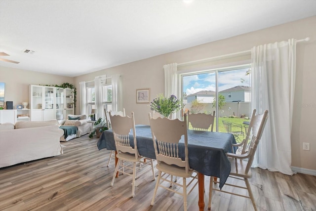 dining area with light hardwood / wood-style floors, a healthy amount of sunlight, and ceiling fan