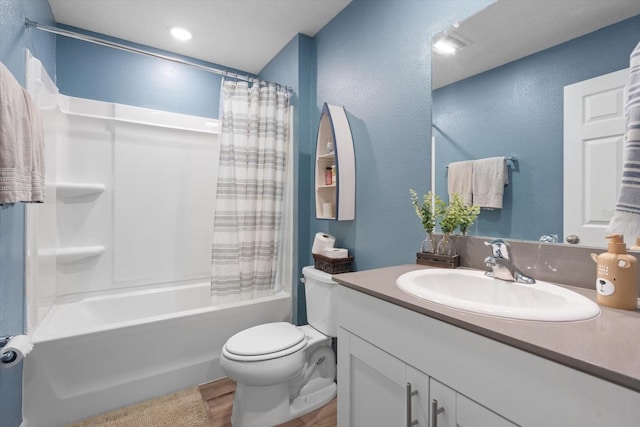 full bathroom featuring vanity, hardwood / wood-style floors, shower / bath combo with shower curtain, and toilet