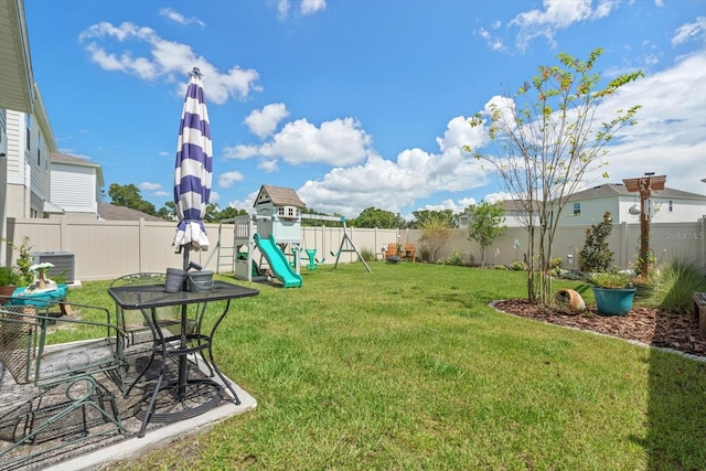 view of yard featuring central air condition unit and a playground