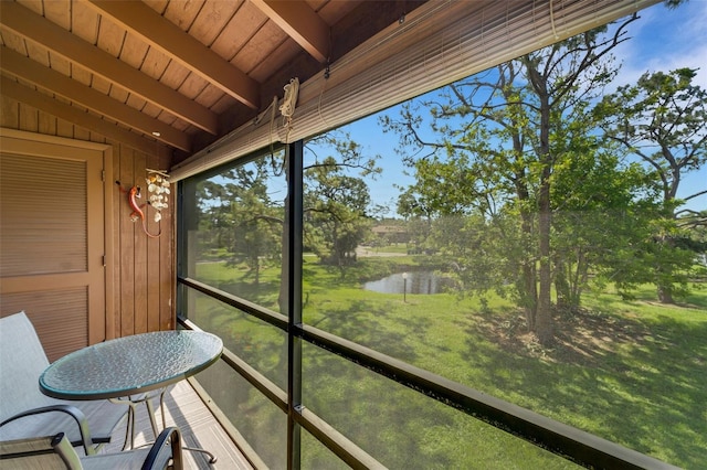 sunroom / solarium with wood ceiling, beam ceiling, and a water view