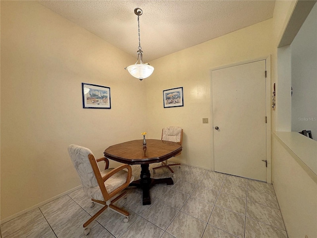 tiled dining room featuring a textured ceiling