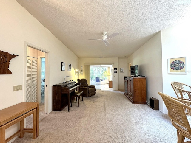 interior space with lofted ceiling, ceiling fan, and a textured ceiling